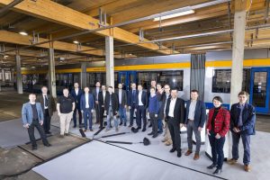 Verkehr der Zukunft: Das Projektteam steht vor einer Straßenbahn