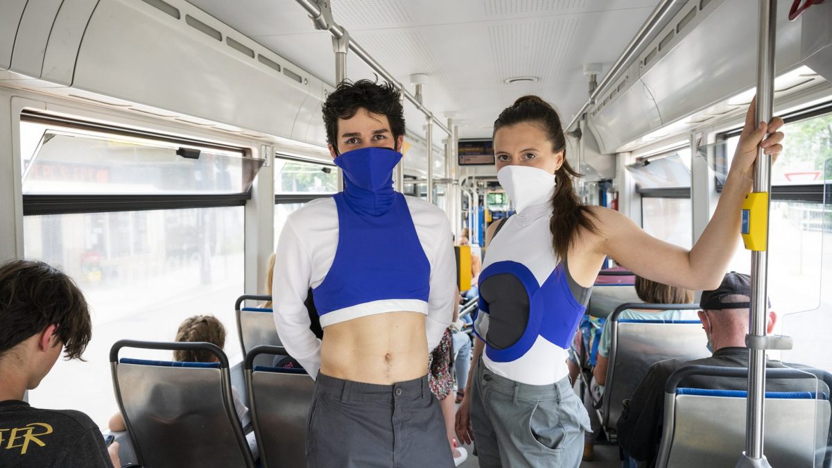 2 Personen in futuristischer Kleidung stehen in Straßenbahn