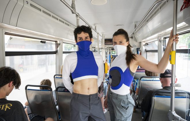 2 Personen in futuristischer Kleidung stehen in Straßenbahn